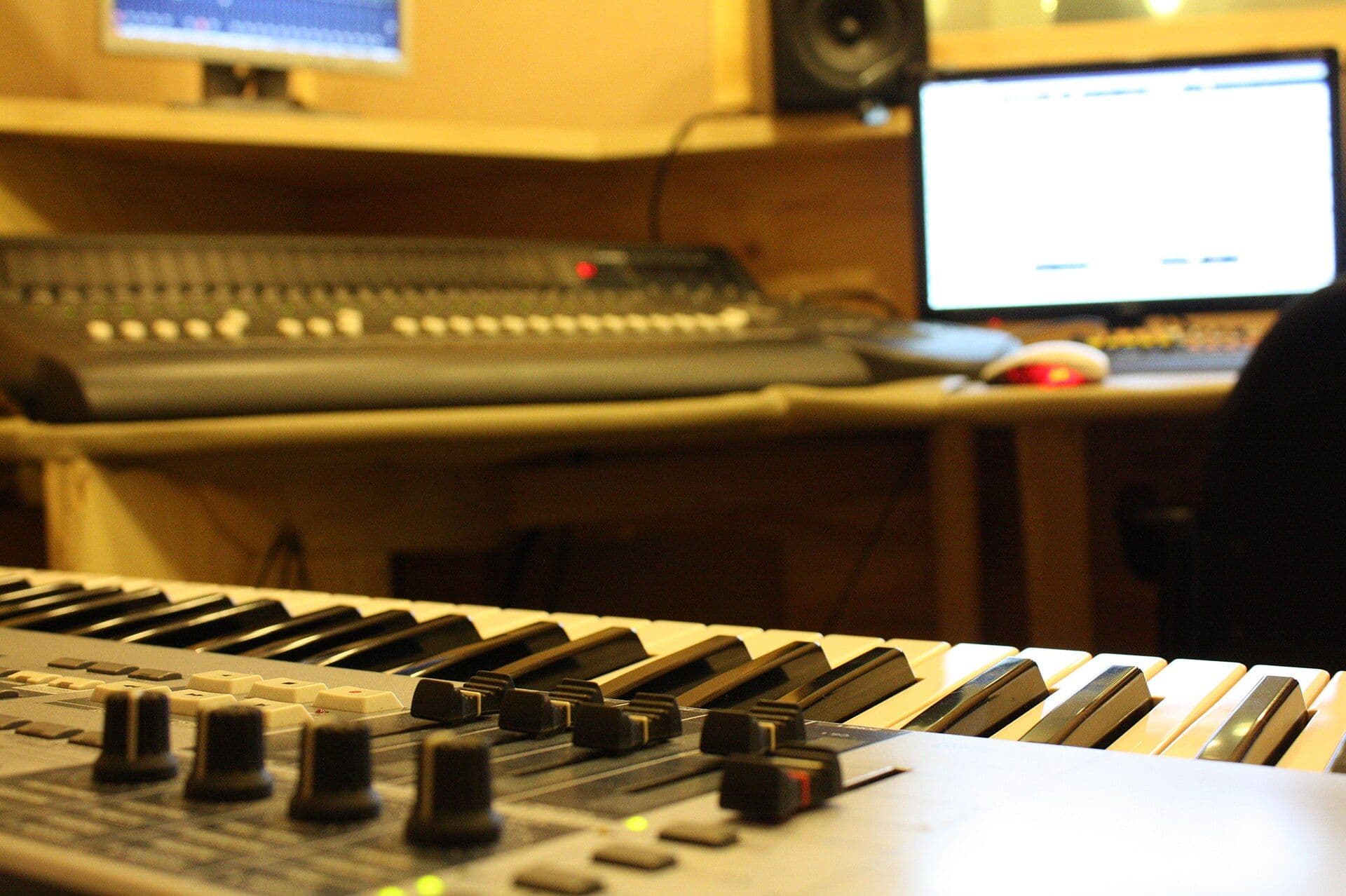 Keyboard synthesizer and mixing console in a recording studio