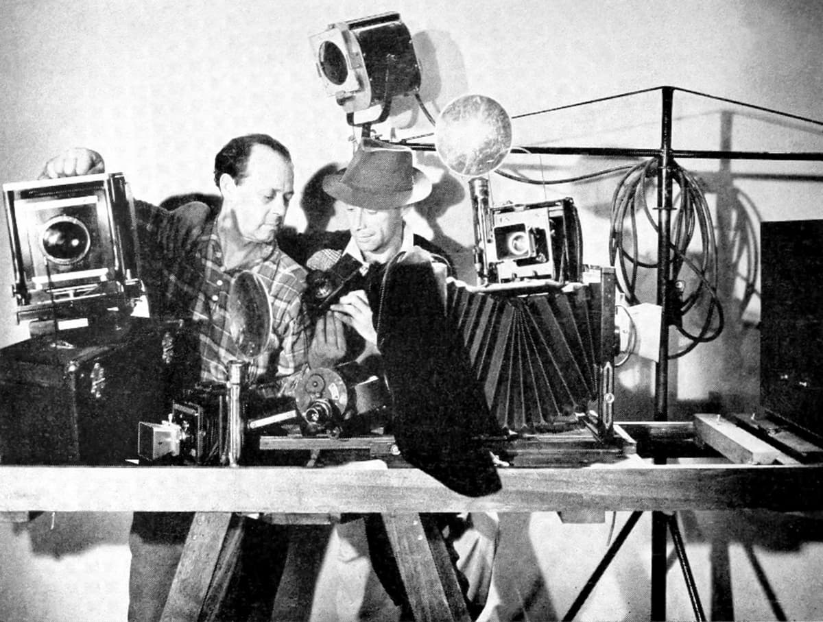 Still photographers with camera and studio lighting equipment