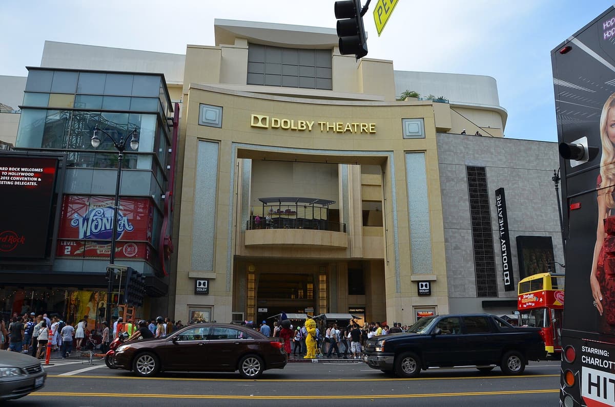 Dolby Theatre facade on Hollywood Boulevard, with traffic on the street and pedestrians near the entrance