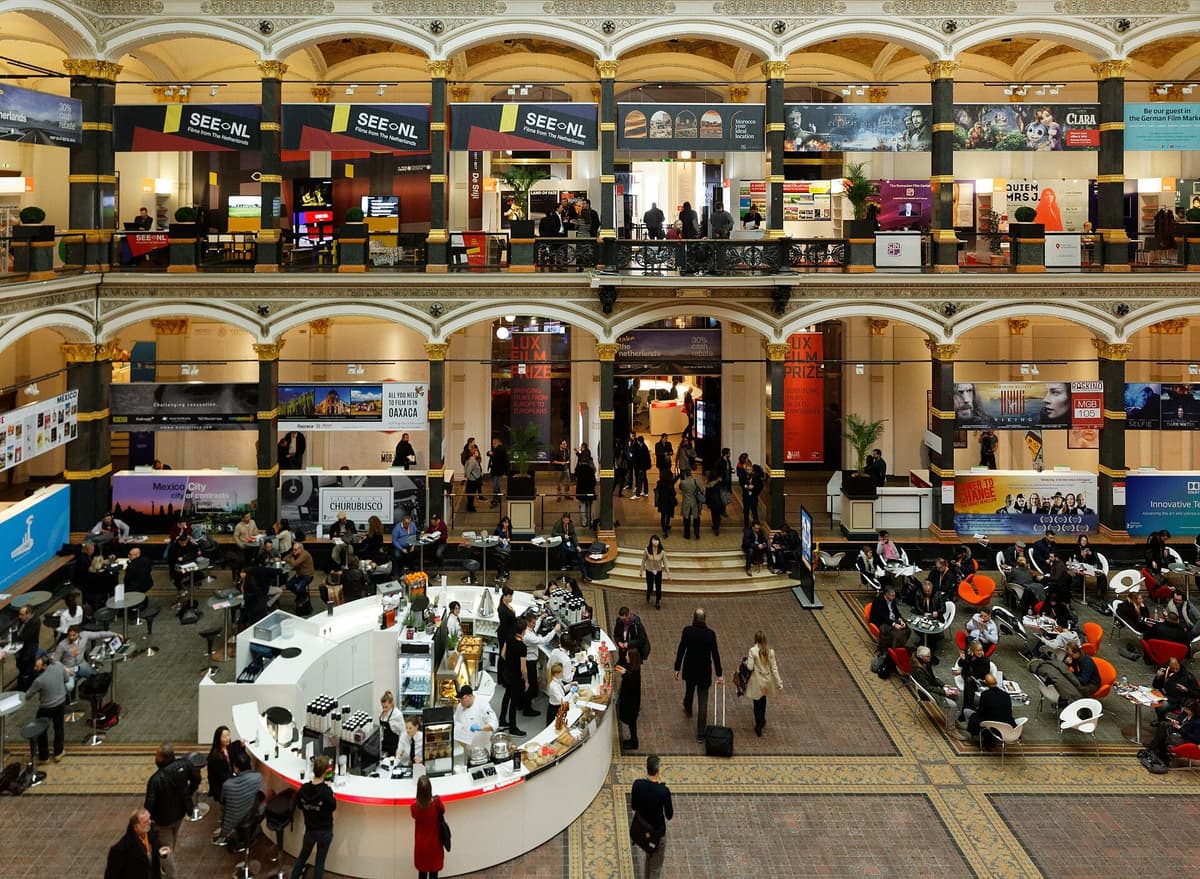 Vendor booths and attendees in the European Film Market hall at the Berlinale