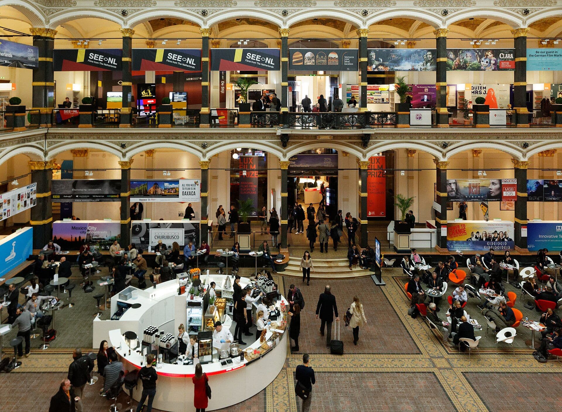 Vendor booths and attendees in the European Film Market hall at the Berlinale