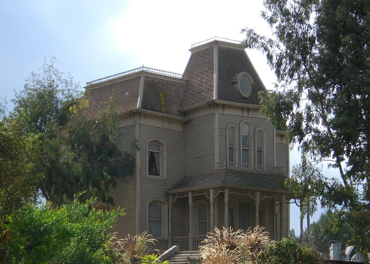 Victorian house with a mansard roof and front porch, the Psycho set at Universal Studios Hollywood, surrounded by trees