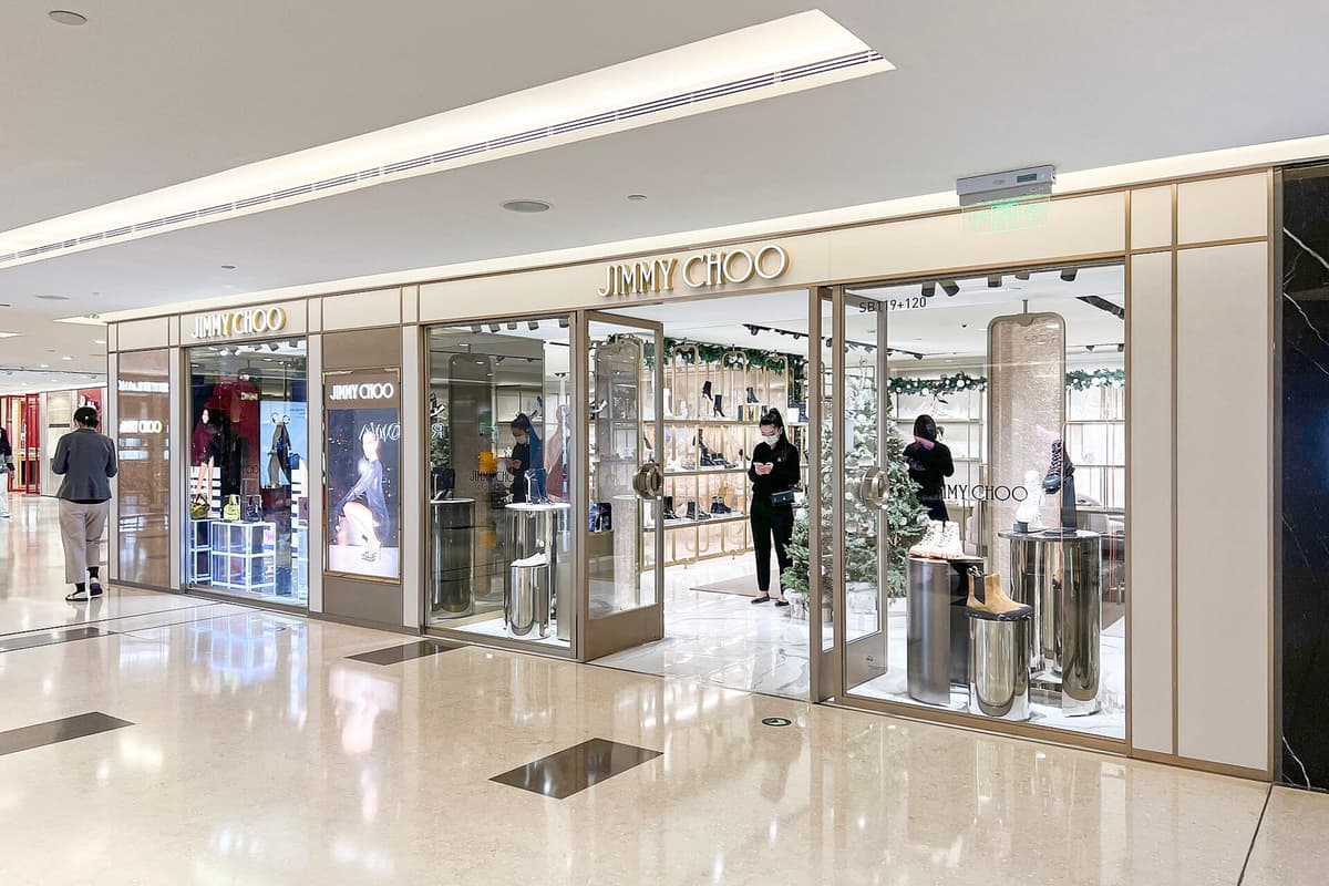 Jimmy Choo boutique in a shopping mall, with shoes displayed in the window and shoppers inside.