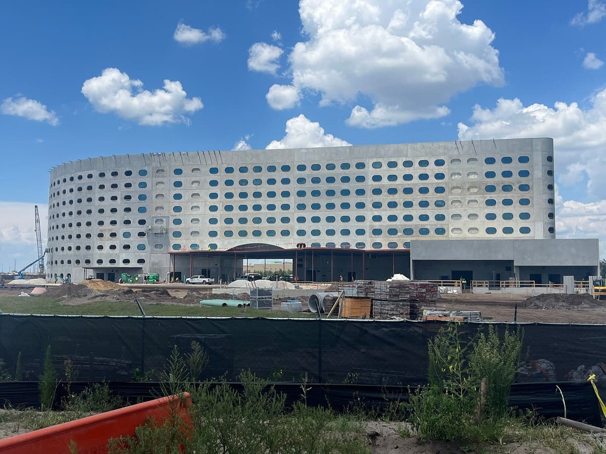 A large concrete building under construction at Universal's Epic Universe, with cranes and equipment visible nearby.