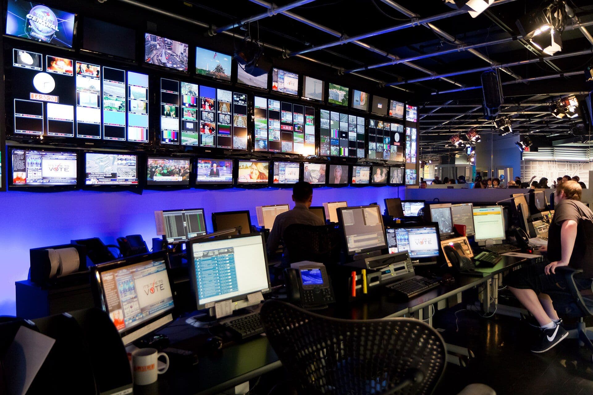 A modern television broadcast control room with multiple monitors and equipment