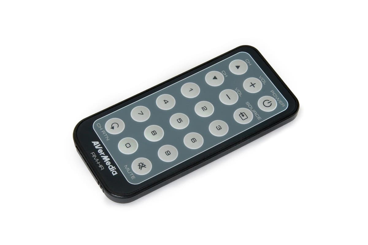 Black remote control with grey rubber number, volume, channel and power buttons, on a white background