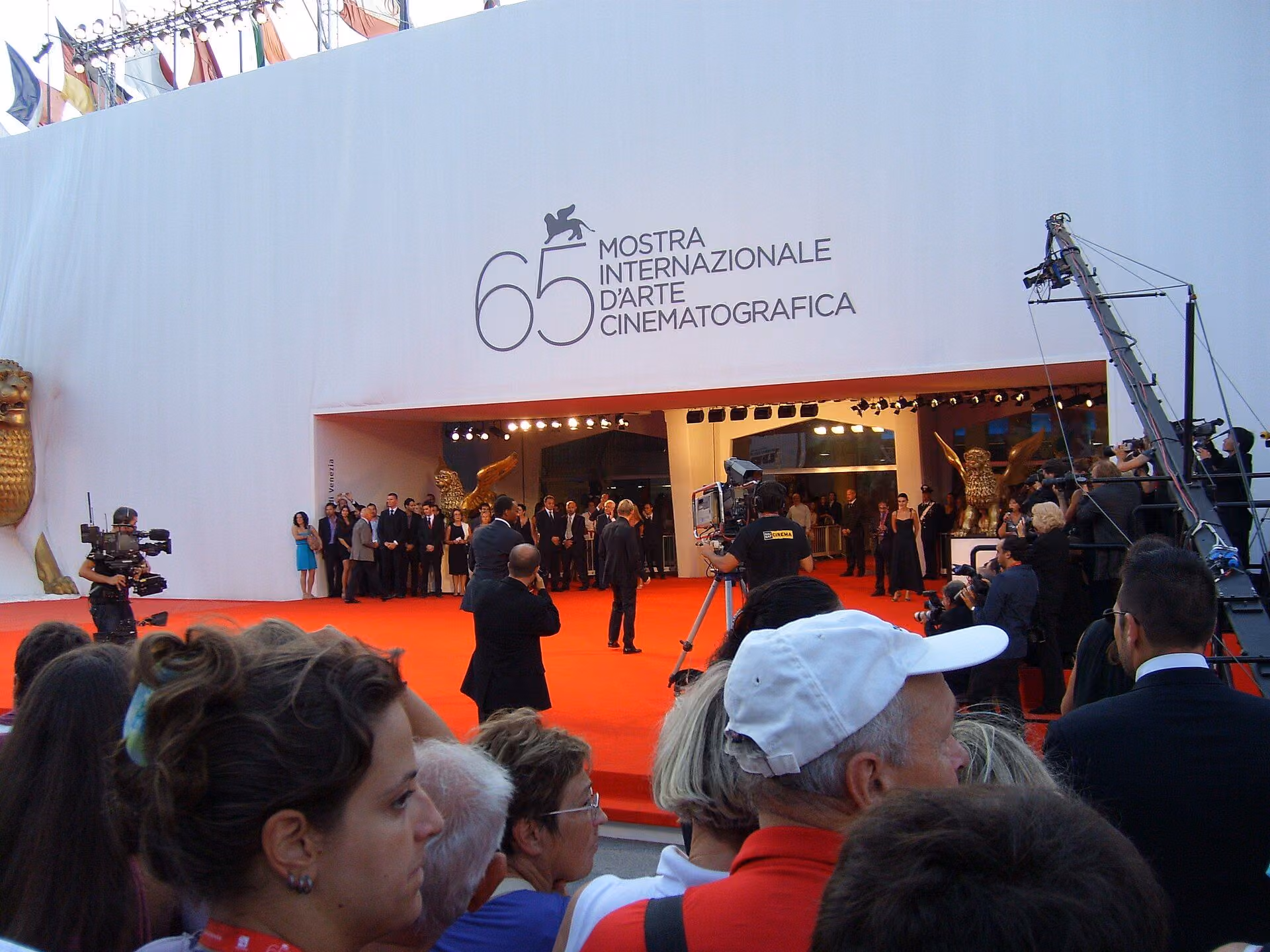 Red carpet at the Venice Film Festival, lined with photographers and a crowd of onlookers