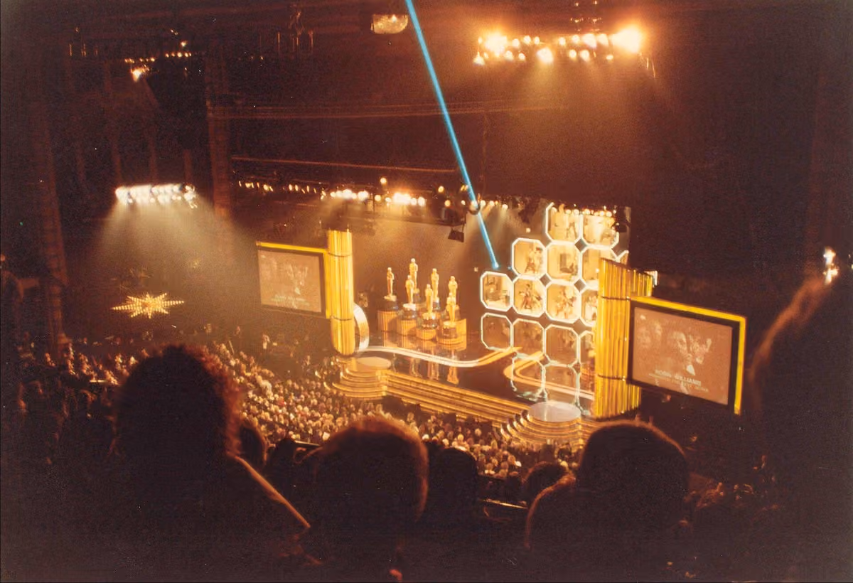 Academy Awards ceremony stage with Oscar statuettes and theatrical lighting