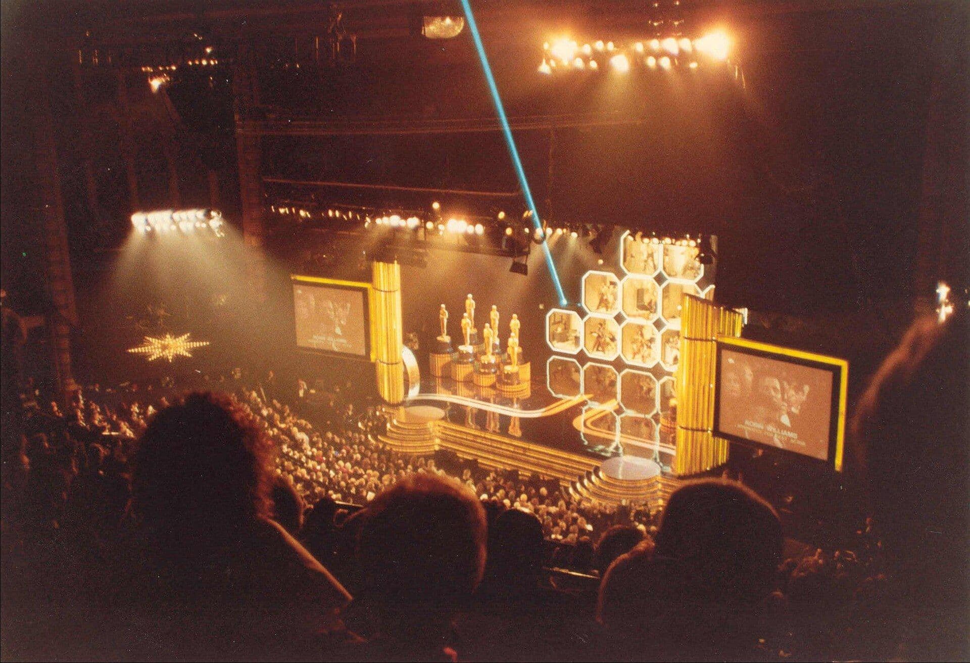 Academy Awards ceremony stage with Oscar statuettes and theatrical lighting