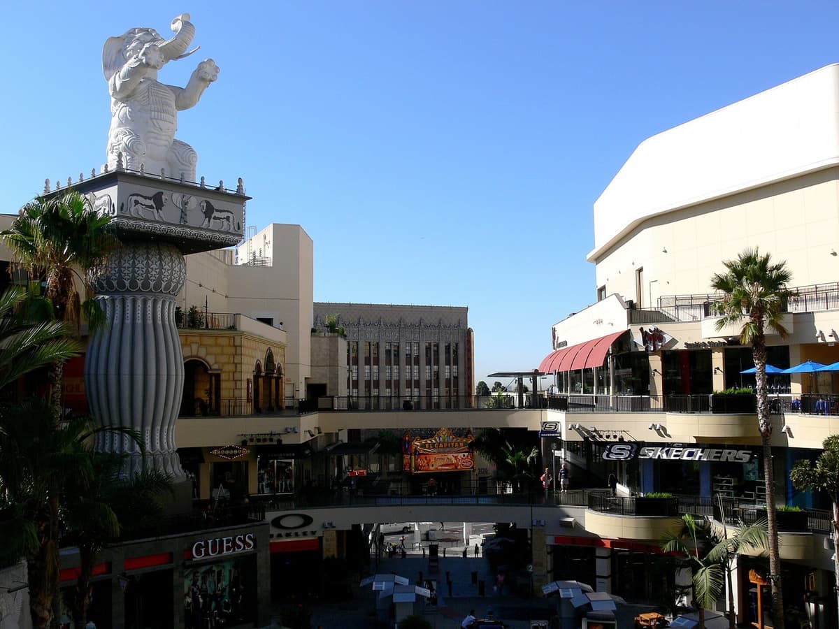 Hollywood entertainment and shopping complex with a white elephant statue on a tall column, palm trees and shops