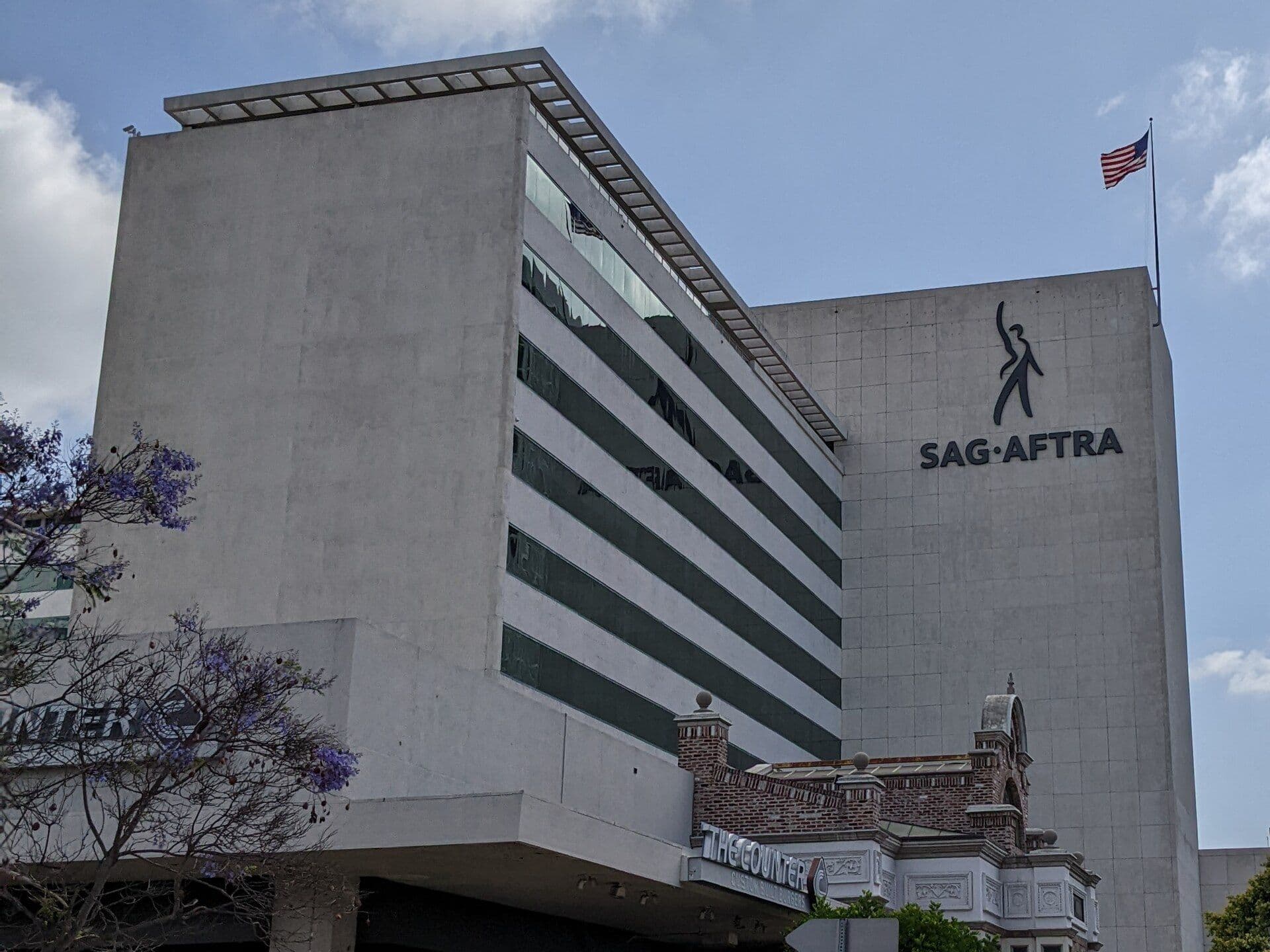 The SAG-AFTRA headquarters building in Los Angeles, California, with its signage and American flag.