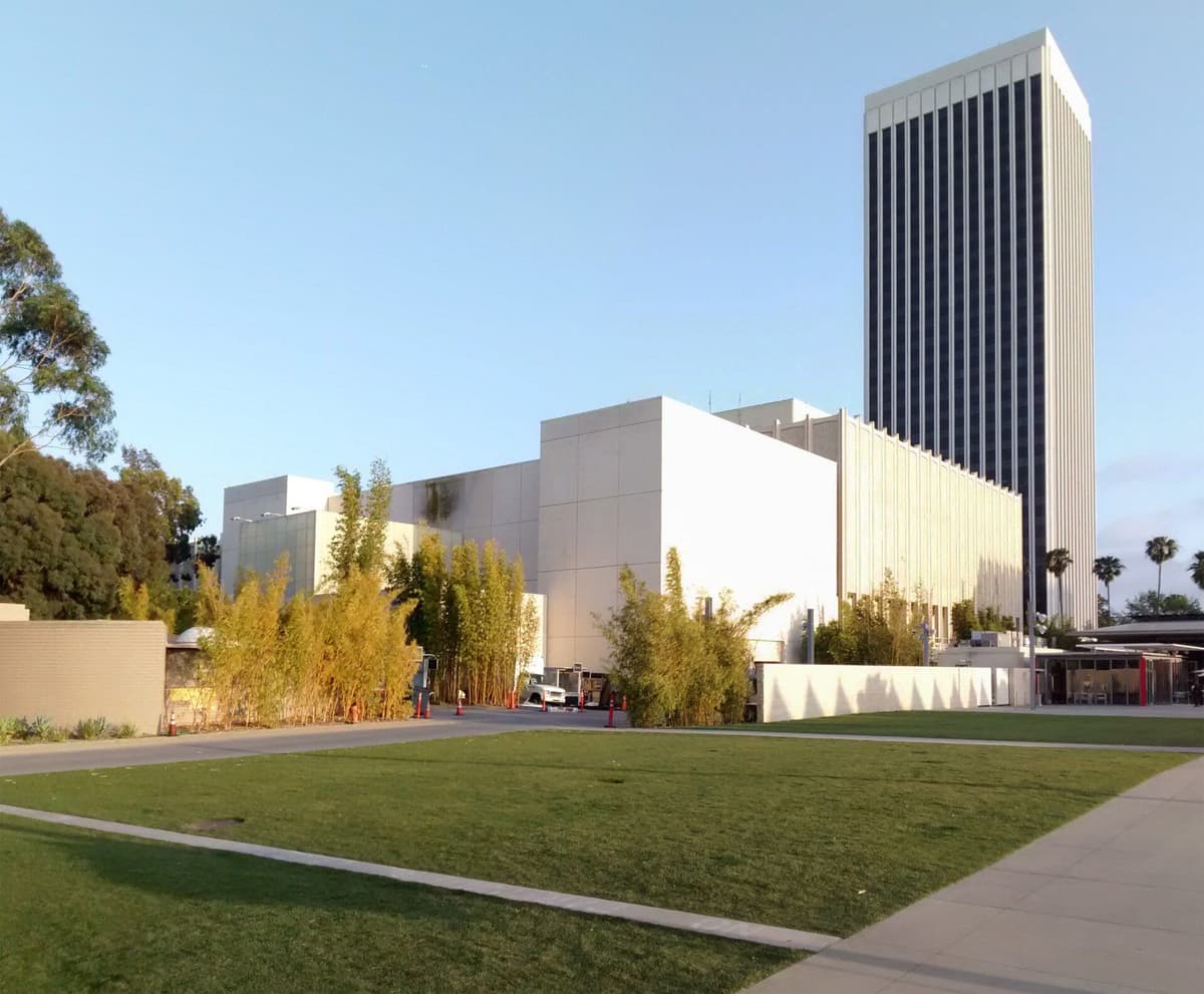 Contemporary LACMA building with vertical ribbed tower and lower pavilions, viewed across green lawn